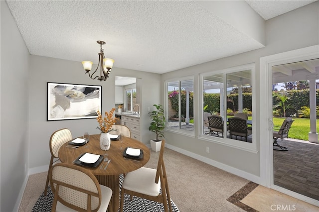 dining space featuring a textured ceiling, light colored carpet, and a notable chandelier