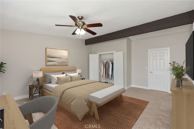 bedroom featuring ceiling fan, carpet, a closet, a textured ceiling, and beamed ceiling