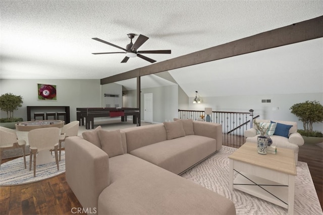 living room with ceiling fan, lofted ceiling with beams, a textured ceiling, and wood-type flooring