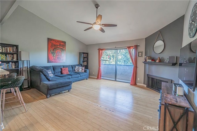 living room featuring ceiling fan, lofted ceiling, and light wood-type flooring