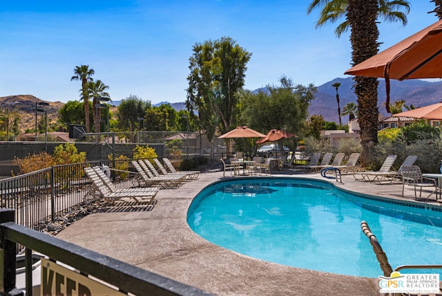 view of pool featuring a mountain view and a patio