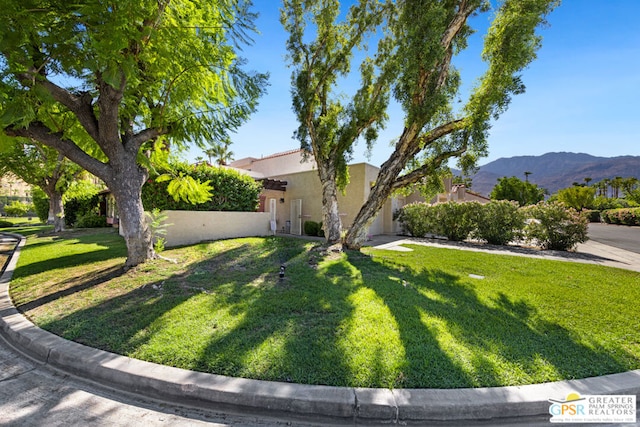 view of front of house with a mountain view and a front yard