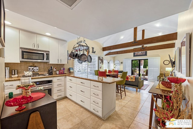 kitchen featuring backsplash, white cabinets, light tile patterned floors, kitchen peninsula, and stainless steel appliances