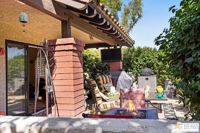 view of patio / terrace with grilling area and a fire pit