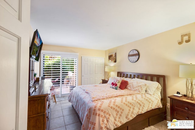 bedroom featuring access to exterior, light tile patterned floors, and a closet