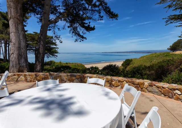 view of patio with a beach view and a water view