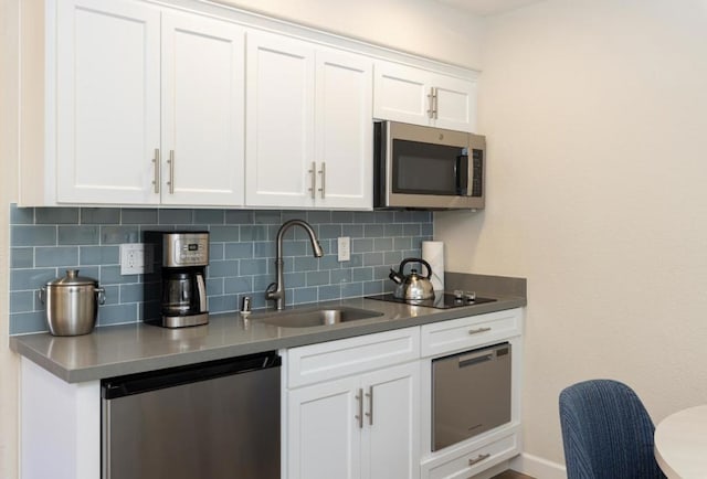 kitchen featuring backsplash, stainless steel appliances, sink, and white cabinets