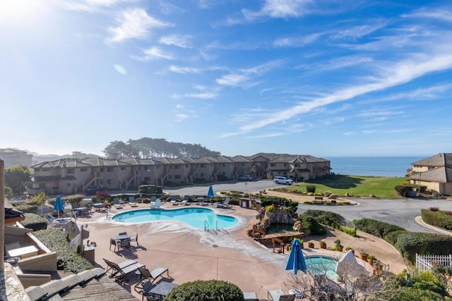 view of swimming pool featuring a patio and a water view