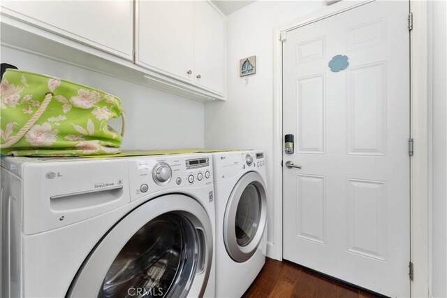 washroom with cabinets, dark hardwood / wood-style flooring, and washer and clothes dryer