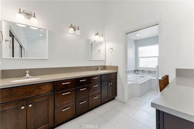 bathroom featuring a relaxing tiled tub, tile patterned flooring, and dual bowl vanity