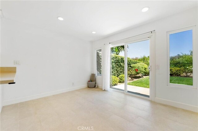 unfurnished room featuring light tile patterned flooring and a healthy amount of sunlight