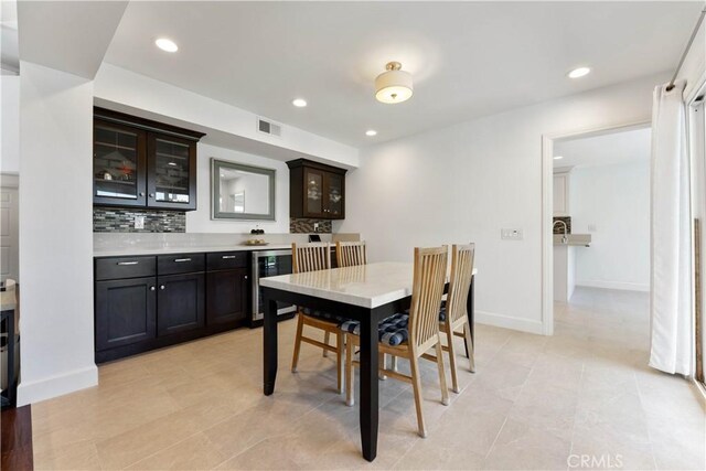 dining area featuring light tile patterned floors and beverage cooler