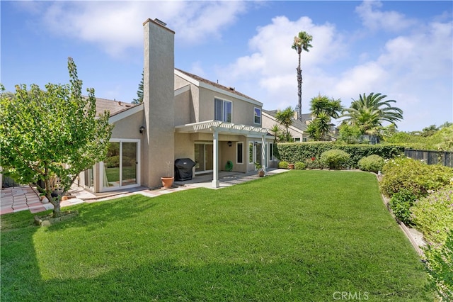 rear view of house featuring a pergola, a patio area, and a lawn