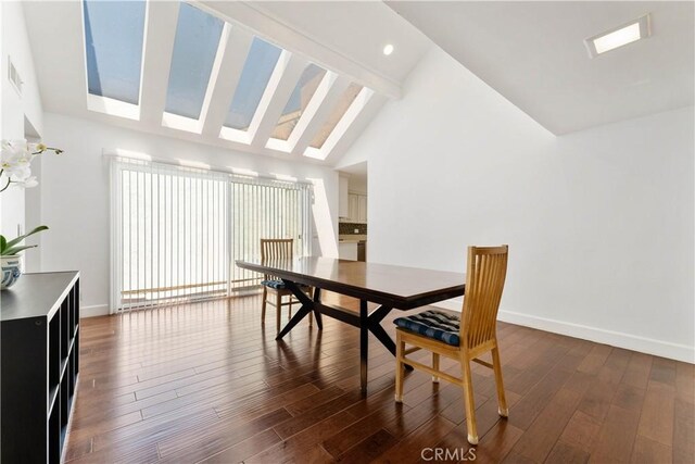 dining area featuring vaulted ceiling with beams and dark hardwood / wood-style flooring