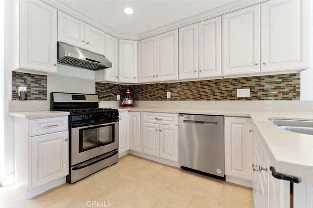 kitchen with light tile patterned floors, white cabinets, stainless steel appliances, and backsplash