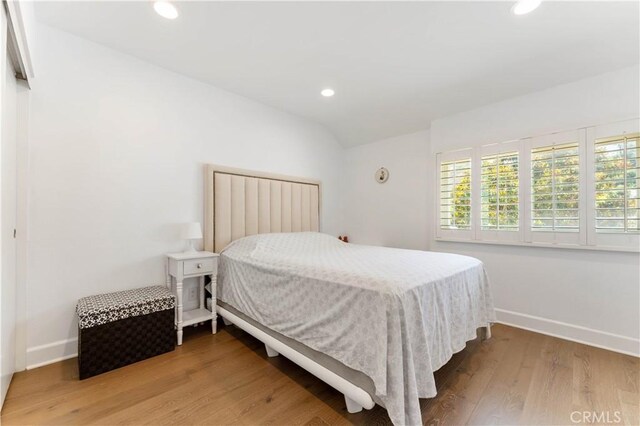 bedroom with light hardwood / wood-style flooring and vaulted ceiling