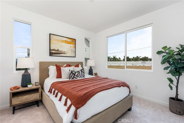 bedroom with light carpet and baseboards