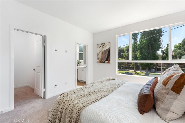 bedroom featuring light carpet and baseboards