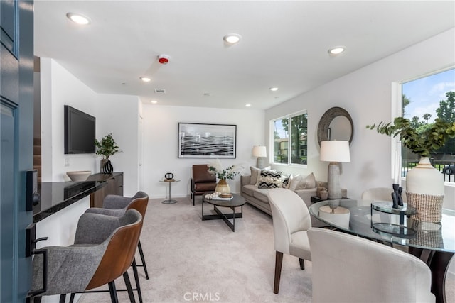 living area featuring recessed lighting, light carpet, and visible vents