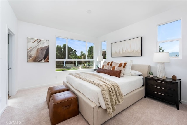 bedroom featuring baseboards and light colored carpet