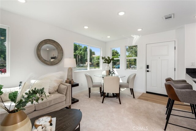 dining room with baseboards, visible vents, light colored carpet, and recessed lighting