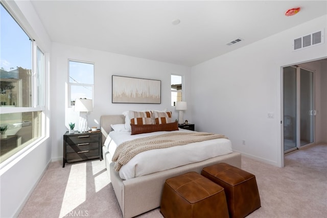 bedroom with light colored carpet, visible vents, and baseboards