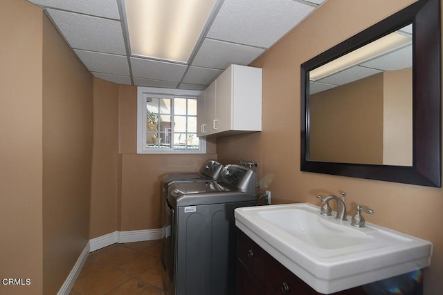 laundry area with sink, tile patterned floors, washing machine and clothes dryer, and cabinets