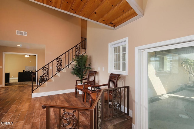 stairs featuring wooden ceiling, high vaulted ceiling, and hardwood / wood-style flooring