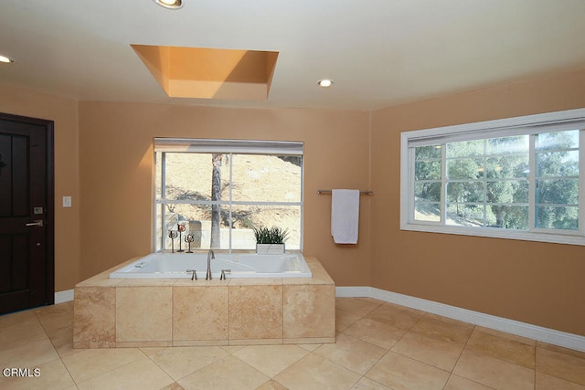 bathroom with a relaxing tiled tub and tile patterned flooring