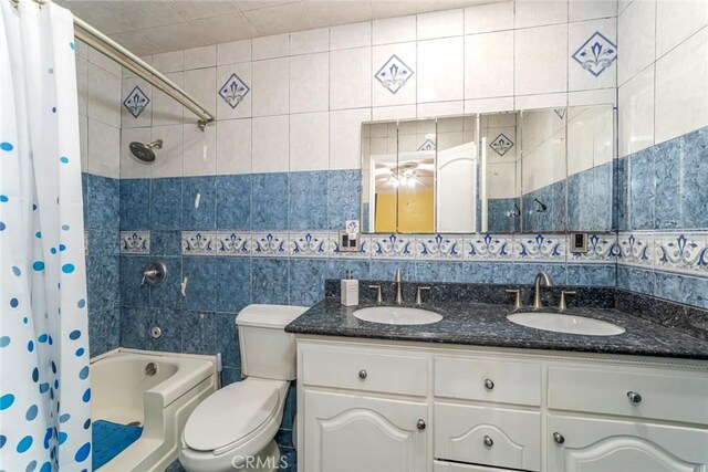 full bathroom featuring tile walls, shower / bath combo, toilet, and double vanity