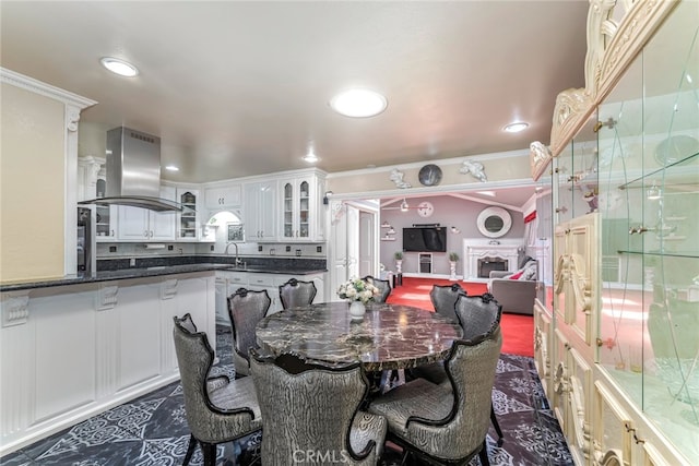 tiled dining area with crown molding and sink