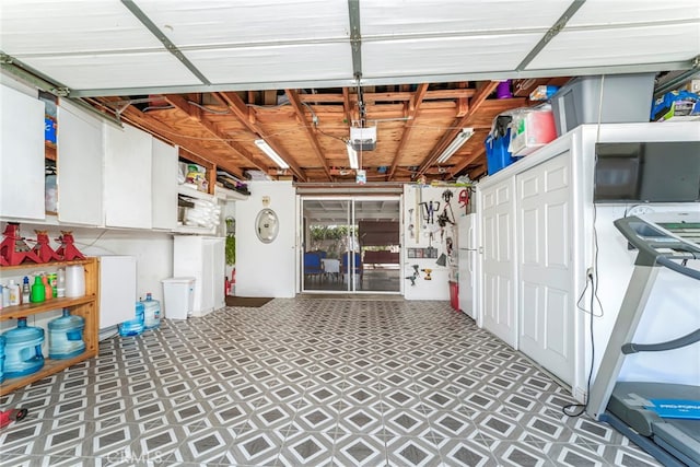 garage featuring white refrigerator and a garage door opener