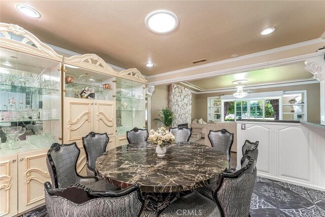 dining area with crown molding and dark tile patterned floors