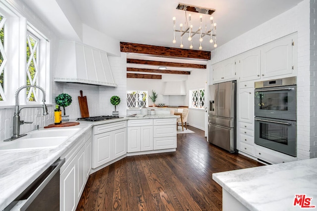 kitchen with white cabinets, appliances with stainless steel finishes, sink, and pendant lighting