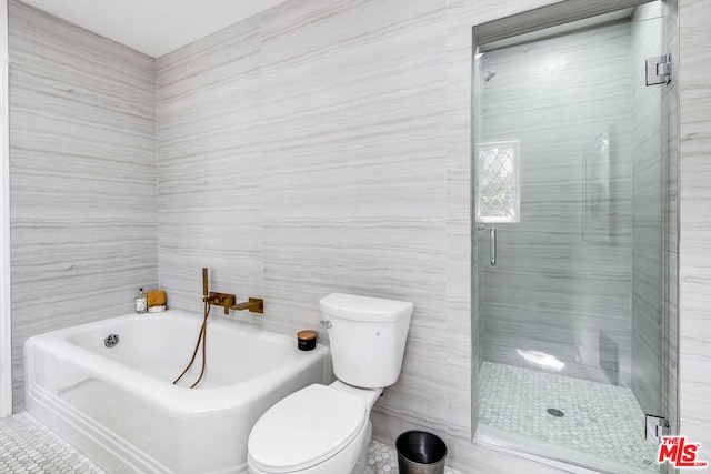 bathroom featuring a tub, tile walls, and toilet