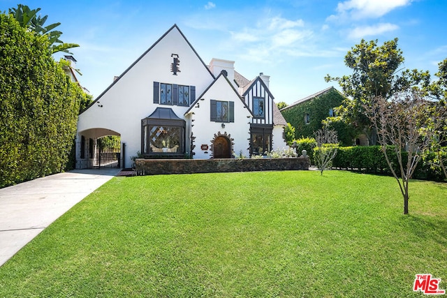 tudor home featuring a front lawn