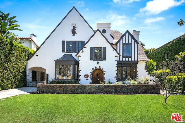 tudor home featuring a front lawn