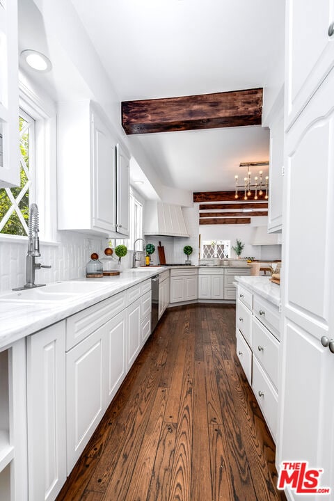 kitchen featuring white cabinets and beamed ceiling