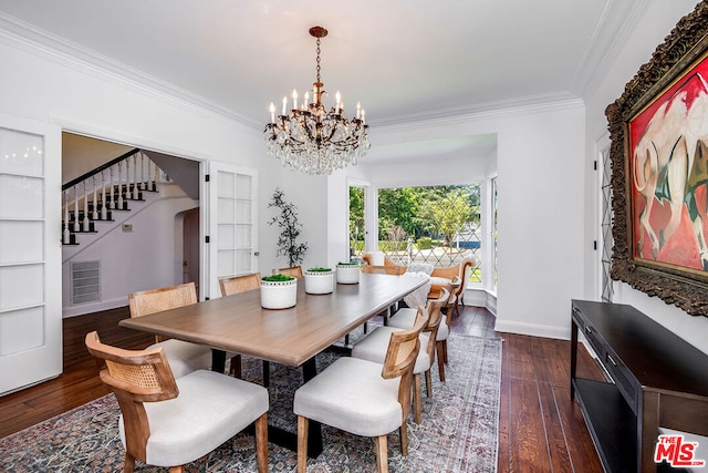 dining area with dark wood-type flooring, a notable chandelier, and crown molding