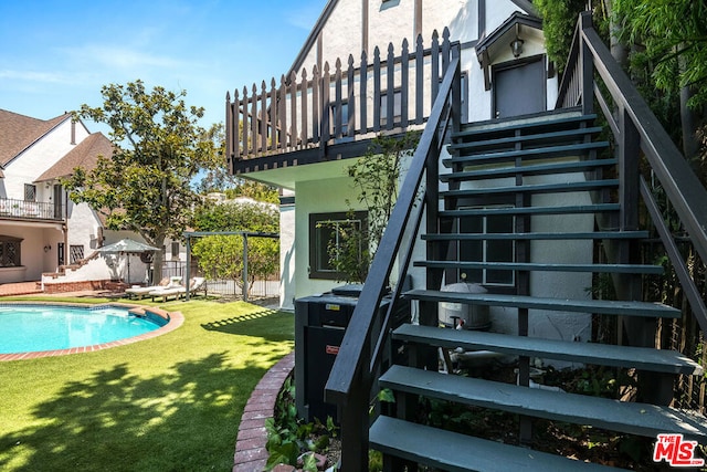 view of pool with a wooden deck and a lawn