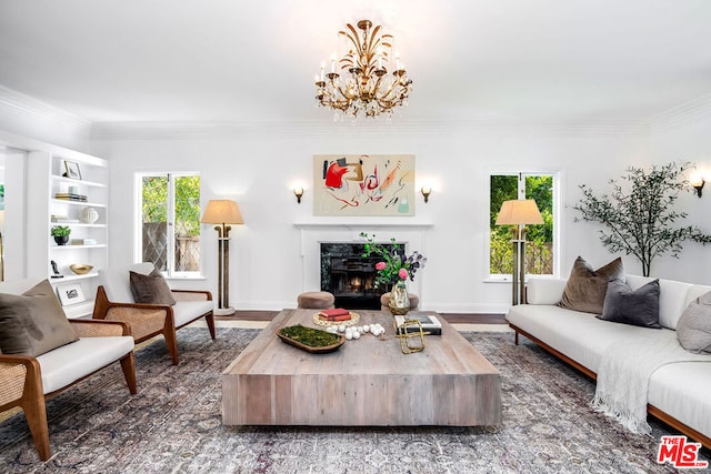 living room featuring hardwood / wood-style flooring, a high end fireplace, ornamental molding, and a chandelier