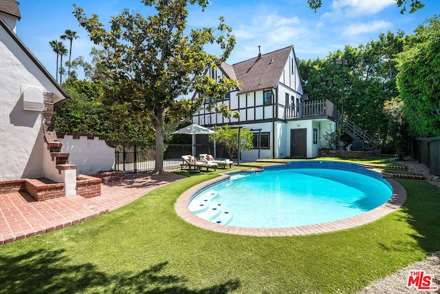 view of pool featuring a lawn and a patio