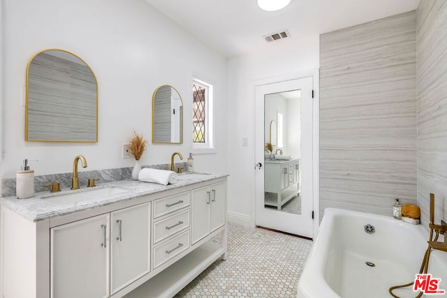 bathroom featuring a bathing tub, tile patterned flooring, and vanity