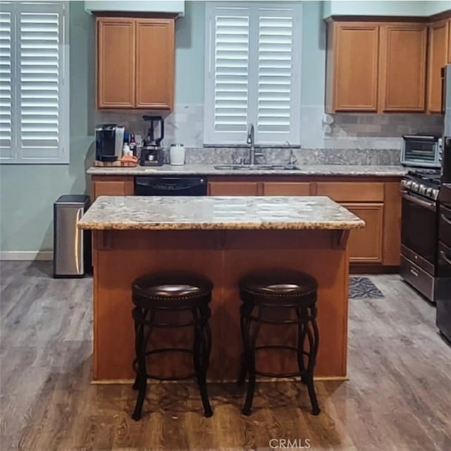 kitchen featuring a kitchen island, dishwasher, hardwood / wood-style flooring, and sink