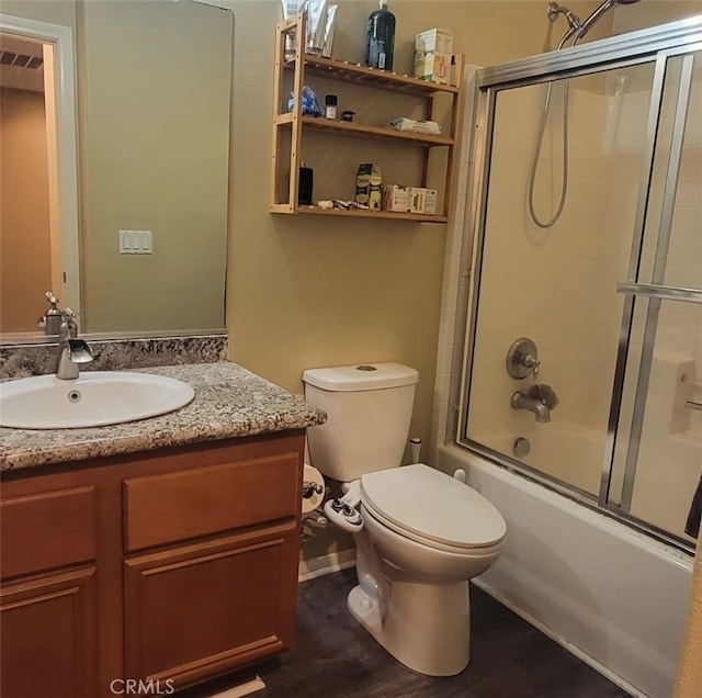 full bathroom with hardwood / wood-style floors, toilet, shower / bath combination with glass door, and vanity