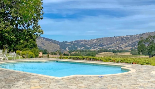 view of pool with a patio area and a mountain view