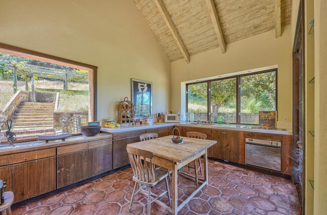 kitchen with high vaulted ceiling, wooden ceiling, wall oven, and beamed ceiling