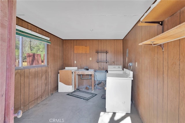 laundry room with wood walls, washer / dryer, and sink