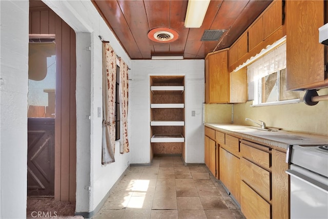 kitchen with custom exhaust hood, light tile patterned floors, sink, stove, and wood ceiling