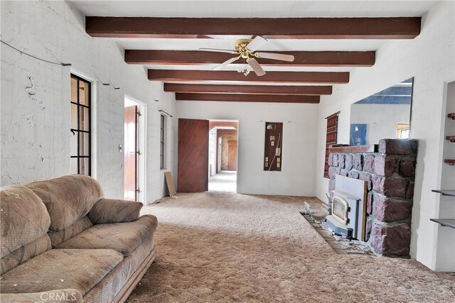 carpeted living room featuring ceiling fan, a wood stove, and beamed ceiling